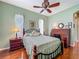 Inviting bedroom with warm hardwood floors, a cozy bed, and a classic rolltop desk at 25222 Laurel Valley Rd, Leesburg, FL 34748