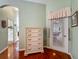 Bedroom dresser with doorway view to a well-lit hallway with hardwood floors at 25222 Laurel Valley Rd, Leesburg, FL 34748