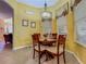 Charming dining area with a round wooden table, decorative chandelier, and window with blinds at 25222 Laurel Valley Rd, Leesburg, FL 34748