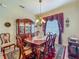 Traditional dining room features an elegant chandelier, wooden furniture, and a decorative china cabinet at 25222 Laurel Valley Rd, Leesburg, FL 34748