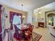 Open concept dining area with elegant chandelier, wooden table and china cabinet, adjacent to the foyer at 25222 Laurel Valley Rd, Leesburg, FL 34748