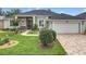 Inviting home features a manicured lawn, walkway and two car garage at 25222 Laurel Valley Rd, Leesburg, FL 34748