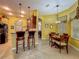 Kitchen with dark wood cabinets, stainless fridge, bar seating and eat-in dining area at 25222 Laurel Valley Rd, Leesburg, FL 34748
