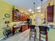 Cozy kitchen with wine rack, bar seating, wood cabinets and stainless steel refrigerator at 25222 Laurel Valley Rd, Leesburg, FL 34748