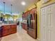 Charming kitchen with a stainless steel refrigerator, wooden cabinets and tile flooring at 25222 Laurel Valley Rd, Leesburg, FL 34748