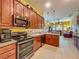 Well-lit kitchen featuring wood cabinetry, stainless steel appliances and tile floors at 25222 Laurel Valley Rd, Leesburg, FL 34748