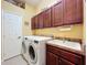 Well-equipped laundry room with washer, dryer, sink, and ample cabinet space at 25222 Laurel Valley Rd, Leesburg, FL 34748