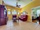 Comfortable living room with a red leather sofa, ceiling fan, and adjacent bedroom doorway at 25222 Laurel Valley Rd, Leesburg, FL 34748