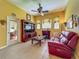 Cozy living room with a fireplace, red leather sofa, and built-in media center at 25222 Laurel Valley Rd, Leesburg, FL 34748