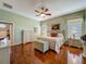 Inviting main bedroom featuring hardwood floors, soft green walls, and a ceiling fan at 25222 Laurel Valley Rd, Leesburg, FL 34748