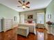 Well-lit main bedroom with hardwood floors, neutral decor, ceiling fan, and ensuite bathroom access at 25222 Laurel Valley Rd, Leesburg, FL 34748