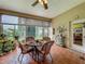 Bright sunroom with tile flooring, large windows, and a dining set for entertaining at 25222 Laurel Valley Rd, Leesburg, FL 34748