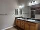 Bright bathroom with dual sinks, large mirror, and walk-in shower at 2530 Hanlon Ter, The Villages, FL 32162
