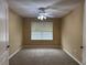 Bedroom features a ceiling fan, large window and neutral carpeting at 2530 Hanlon Ter, The Villages, FL 32162