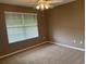Carpeted bedroom features a ceiling fan and large window with horizontal blinds at 2530 Hanlon Ter, The Villages, FL 32162
