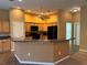 Open kitchen area with wood cabinetry, black appliances, and a breakfast bar at 2530 Hanlon Ter, The Villages, FL 32162