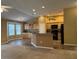 Bright kitchen featuring wood cabinets, black appliances, breakfast bar, and adjacent living space at 2530 Hanlon Ter, The Villages, FL 32162