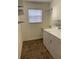 Functional laundry room with ample storage, shelving, and a convenient wash sink at 2530 Hanlon Ter, The Villages, FL 32162