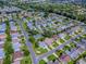Aerial view of a residential community with tree-lined streets and well-maintained homes and a lake at 2799 Privada Dr, The Villages, FL 32162