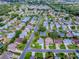 Beautiful aerial view of a meticulously landscaped community, showcasing a network of well-maintained homes and lush greenery at 2799 Privada Dr, The Villages, FL 32162