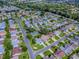 Aerial view of a residential community with tree-lined streets and well-maintained homes and a lake at 2799 Privada Dr, The Villages, FL 32162