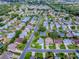 Community aerial view showcasing lush green landscaping, well-maintained homes, and a tranquil neighborhood setting at 2799 Privada Dr, The Villages, FL 32162