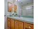 Bathroom vanity with blue countertop, wood cabinets, single sink, and mirror at 2799 Privada Dr, The Villages, FL 32162
