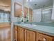 Bathroom vanity with blue countertop, wood cabinets, sink, and view into bedroom at 2799 Privada Dr, The Villages, FL 32162