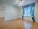 A spacious bedroom with a fan, wood floors, and a decorative window treatment at 2799 Privada Dr, The Villages, FL 32162