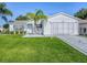Charming single-story home with well-manicured lawn, white siding, and a decorative palm tree in the front yard at 2799 Privada Dr, The Villages, FL 32162