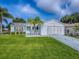 Charming home exterior features lush lawn, manicured landscaping, and a welcoming entrance at 2799 Privada Dr, The Villages, FL 32162