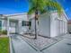 Close up of the front exterior with a palm tree, decorative rocks, and light-colored siding, presenting a clean, inviting entrance at 2799 Privada Dr, The Villages, FL 32162