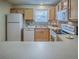 Cozy kitchen featuring stainless sink, white appliances, wood cabinets, and backsplash at 2799 Privada Dr, The Villages, FL 32162