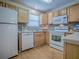 Well-lit kitchen with white appliances, wood cabinets and a stylish backsplash at 2799 Privada Dr, The Villages, FL 32162