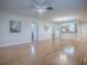 Bright, open-concept living space with hardwood floors, a ceiling fan, and a view of the adjacent kitchen area at 2799 Privada Dr, The Villages, FL 32162