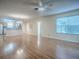 Open floor plan features wood floors, ceiling fan, and views to the kitchen and bathroom, enhancing the living experience at 2799 Privada Dr, The Villages, FL 32162