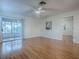 Spacious living area with wood floors, neutral walls, and ceiling fan, plus glimpses into the kitchen and bathroom at 2799 Privada Dr, The Villages, FL 32162