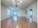Bright living room with wood floors, neutral walls, blinds, and sliding door access to the outdoor screened patio at 2799 Privada Dr, The Villages, FL 32162