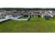 Aerial view of the backyard featuring a lush green lawn, white fence, and a screened-in patio at 29810 Anahid Dr, Leesburg, FL 34748