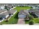 This aerial view showcases a home with a brick driveway, lush lawn, and flowering tree at 29810 Anahid Dr, Leesburg, FL 34748