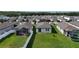 Aerial view of the backyard featuring a lush green lawn, white fence, screened-in patio and a trampoline at 29810 Anahid Dr, Leesburg, FL 34748