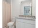 Modern bathroom with a granite countertop, complemented by neutral tones, and a shower with patterned curtain at 29810 Anahid Dr, Leesburg, FL 34748