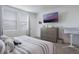 Functional bedroom including a bed, dresser, TV, and baby bassinet, designed for comfort and convenience at 29810 Anahid Dr, Leesburg, FL 34748