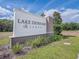The Lake Denham Estates community sign is surrounded by lush landscaping at 29810 Anahid Dr, Leesburg, FL 34748