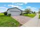 A lovely home with a brick driveway and beautiful tree, showcasing a well-kept lawn at 29810 Anahid Dr, Leesburg, FL 34748