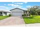 Charming one-story home featuring a brick-paved driveway and a well-manicured lawn at 29810 Anahid Dr, Leesburg, FL 34748