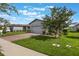 A charming home with a brick driveway and lush lawn, shaded by a blossoming tree at 29810 Anahid Dr, Leesburg, FL 34748