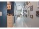 Bright hallway with neutral walls, tiled floors, and decorative wall hangings leading to a sunlit living area at 29810 Anahid Dr, Leesburg, FL 34748