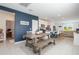 Open-concept kitchen and dining area with stainless appliances, a blue accent wall and tile flooring at 29810 Anahid Dr, Leesburg, FL 34748