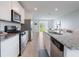 Clean kitchen featuring stainless steel appliances and tile flooring with living room view at 29810 Anahid Dr, Leesburg, FL 34748